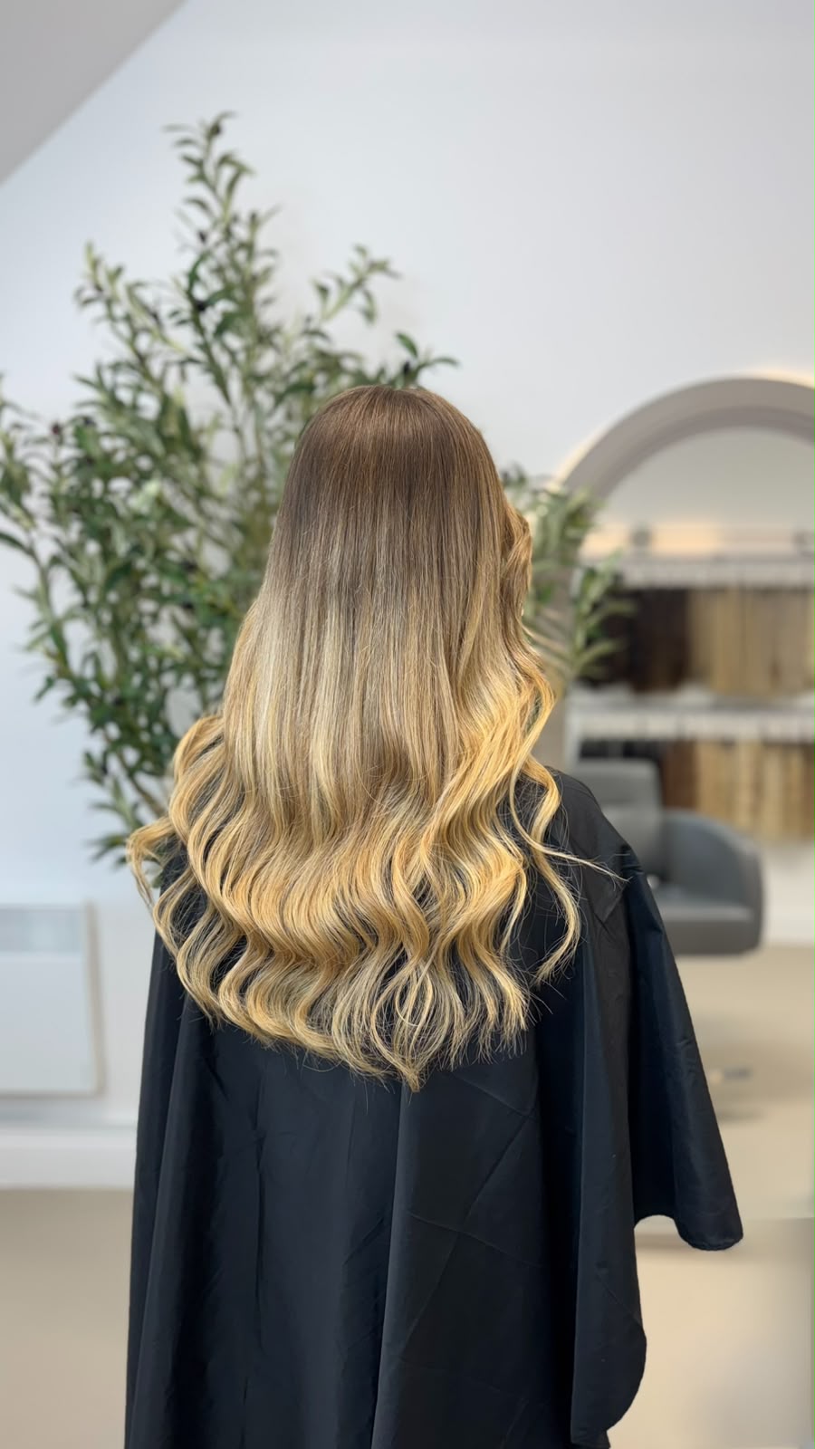 Back view of bronde balayage extensions, warm mid-brown at the root softening to lighter lengths